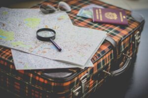 suitcase, magnifying glass, map, and passport
